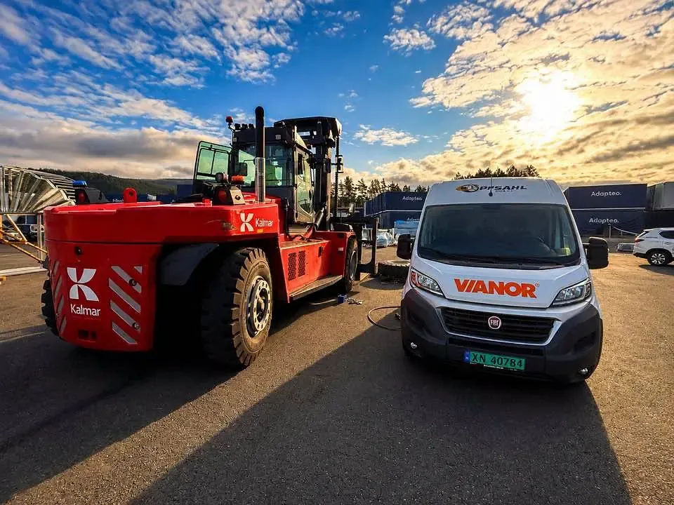Servicebil fra Opsahl Dekk på oppdrag i skumringen ved en containertruck